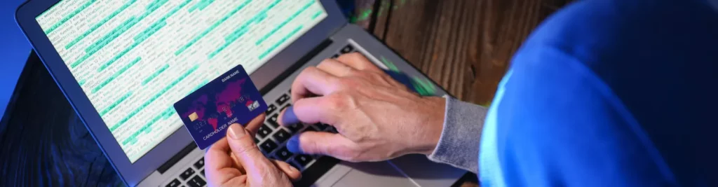 Person typing a card number on a laptop, illustrating how to avoid scams in Australia